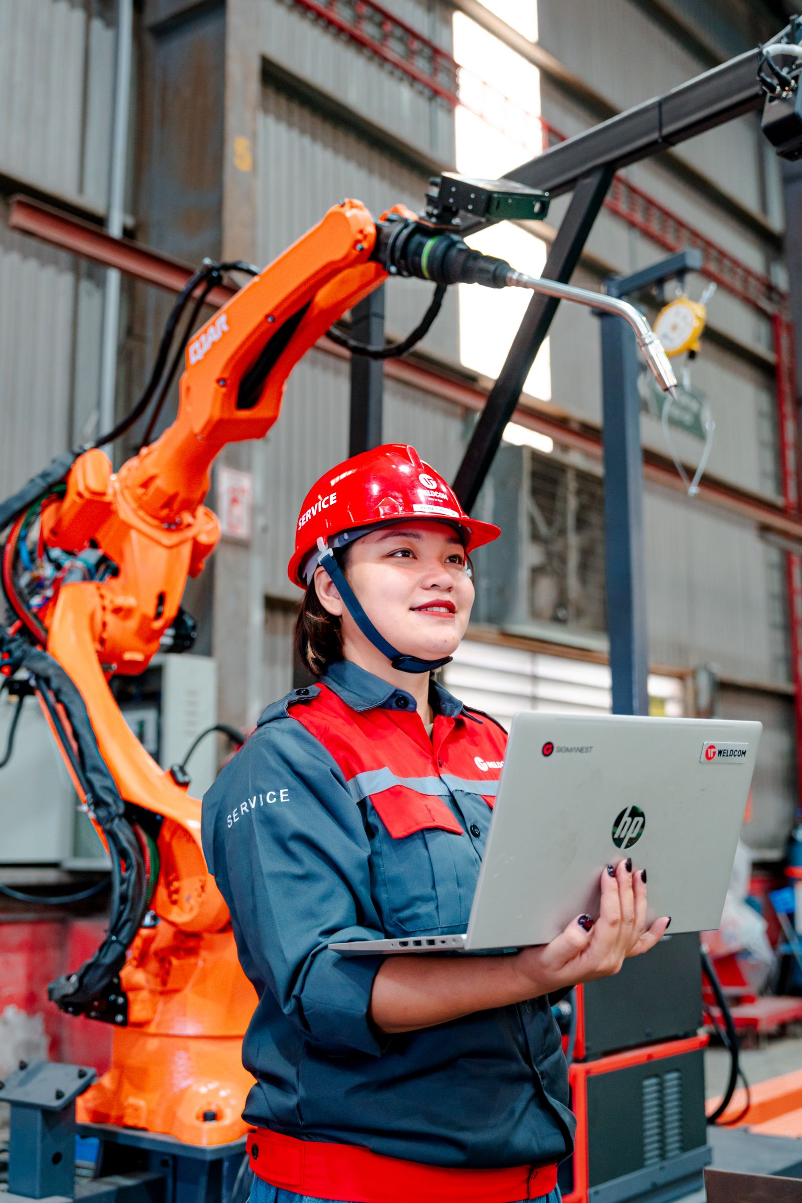Ingenieurin überwacht automatisierte Anlagen mit Laptop