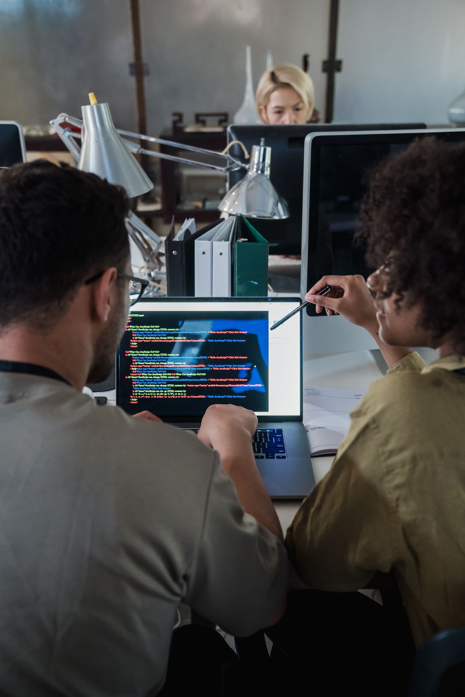 Two developers engage in software programming on a laptop
